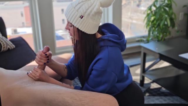 Милашка хорошенько доит большой член прежде чем взять его в рот